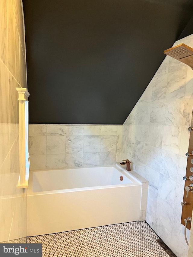 bathroom featuring tile walls, tile patterned flooring, and a bathing tub