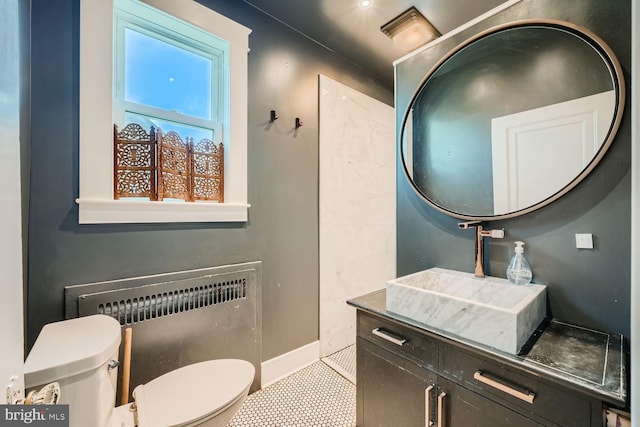 bathroom featuring toilet, radiator heating unit, vanity, and tile patterned floors