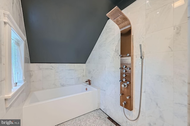 bathroom featuring tile walls, plus walk in shower, and lofted ceiling