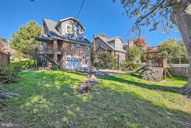 back of property with a playground, a garage, and a lawn