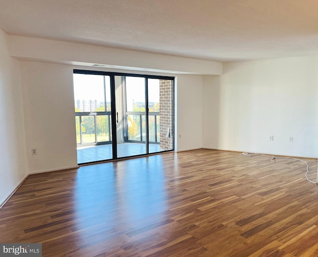 empty room featuring dark wood-type flooring and a textured ceiling