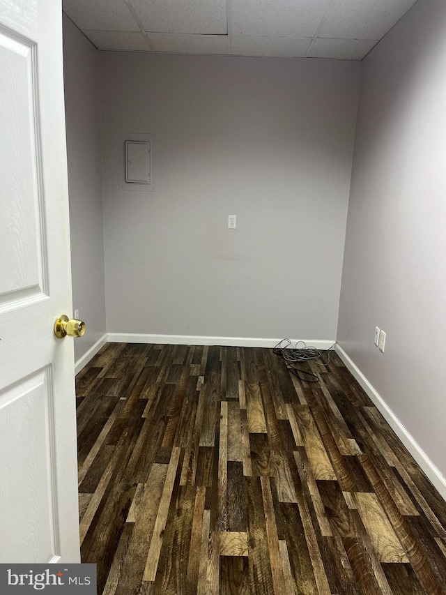 unfurnished room with a drop ceiling and dark hardwood / wood-style flooring