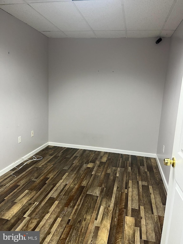 spare room featuring a drop ceiling and dark hardwood / wood-style floors