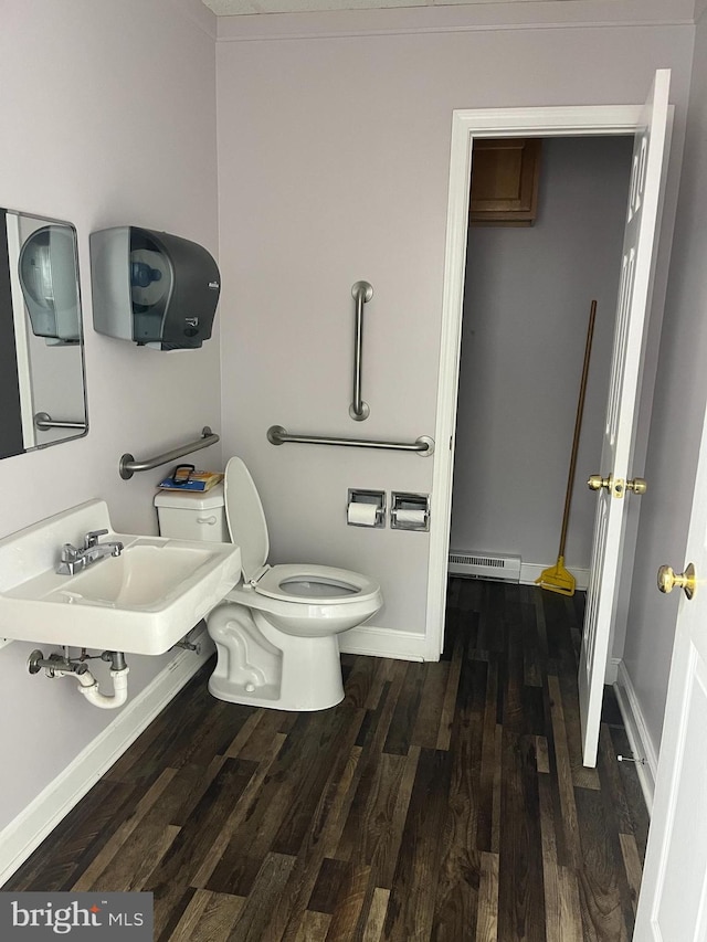 bathroom featuring sink, toilet, wood-type flooring, and baseboard heating