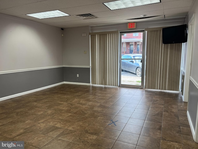 unfurnished room featuring a drop ceiling