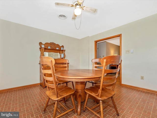 dining area featuring visible vents, baseboards, brick patterned floor, and ceiling fan