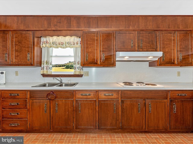 kitchen with decorative backsplash, sink, and white stovetop