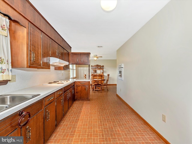 kitchen featuring ceiling fan, sink, and white cooktop