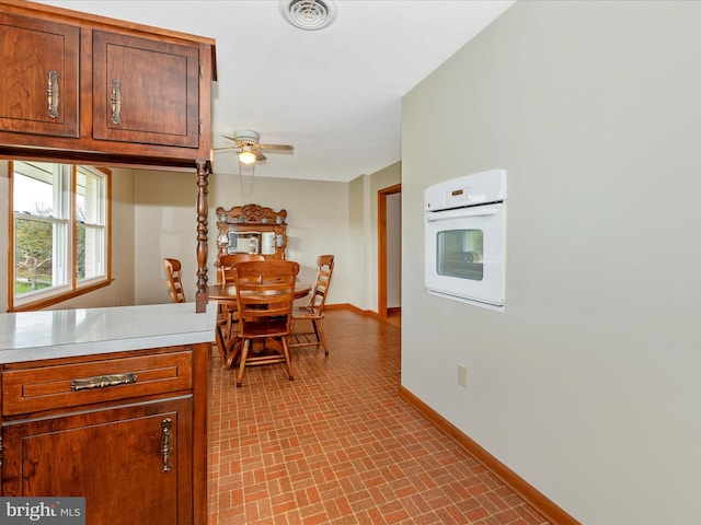 kitchen featuring white oven and ceiling fan