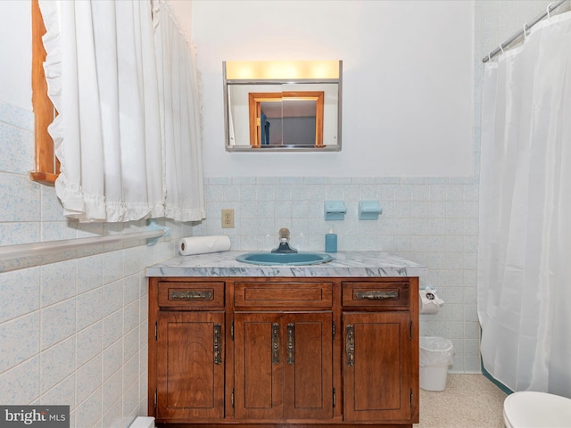 bathroom with vanity, tile walls, and toilet