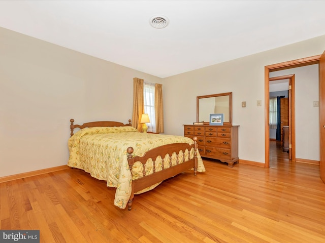 bedroom featuring visible vents, baseboards, and light wood-type flooring