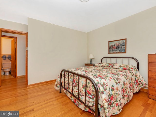 bedroom featuring light hardwood / wood-style floors and ensuite bath