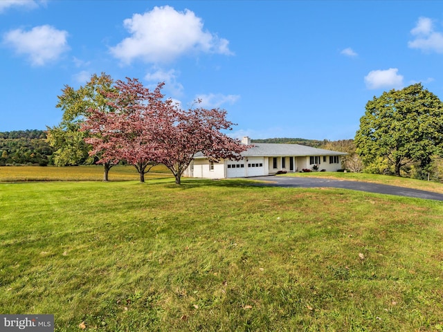 view of front of house featuring a garage, a front yard, and driveway