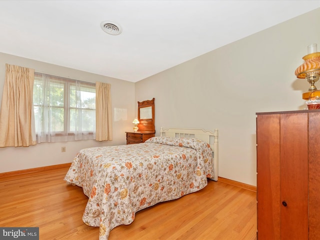 bedroom featuring visible vents, baseboards, and light wood-style flooring