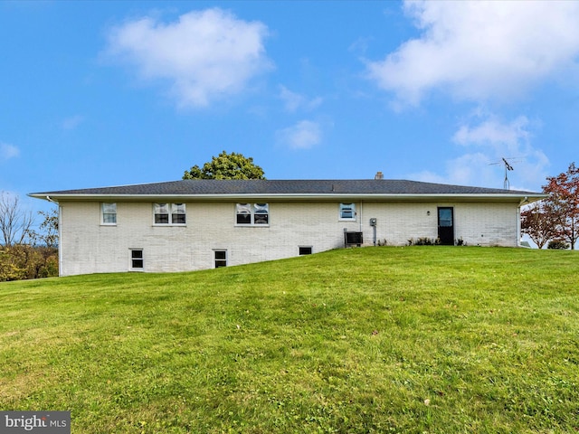 back of property featuring a yard and central AC