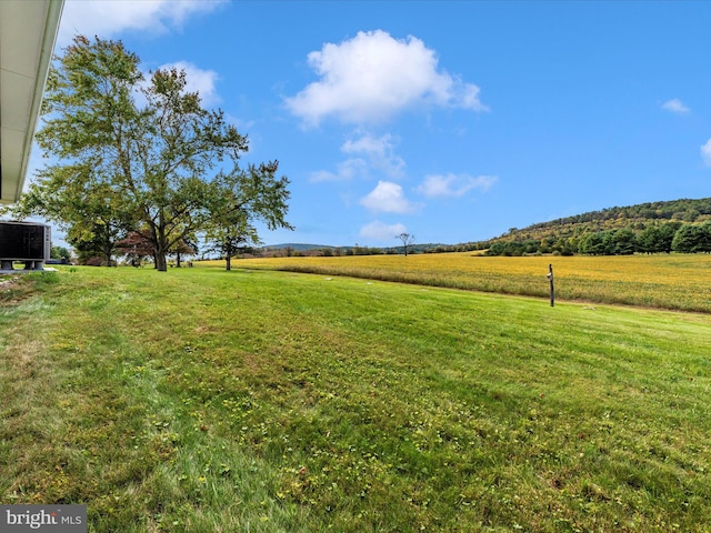 view of yard with a rural view and central AC