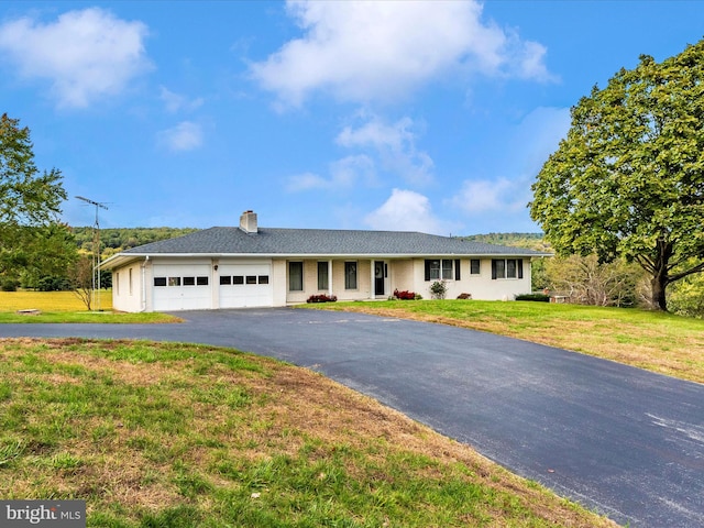 ranch-style home with a garage and a front yard