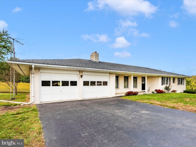 ranch-style home with aphalt driveway, a front yard, a garage, and brick siding