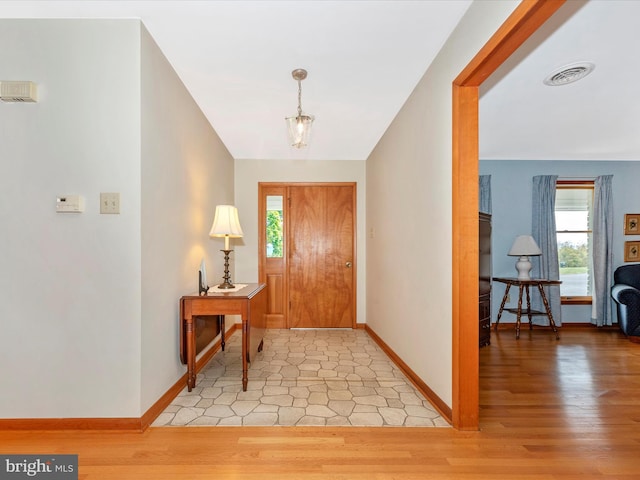 entryway with visible vents, light wood-type flooring, and baseboards