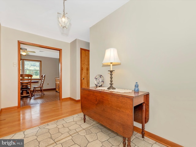 interior space with light wood-type flooring, baseboards, and ceiling fan