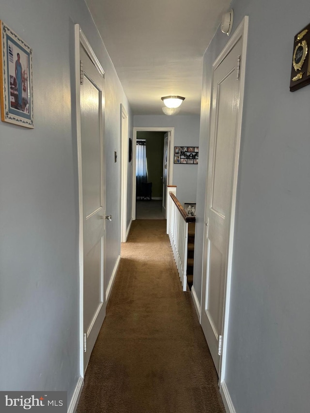 corridor featuring dark colored carpet