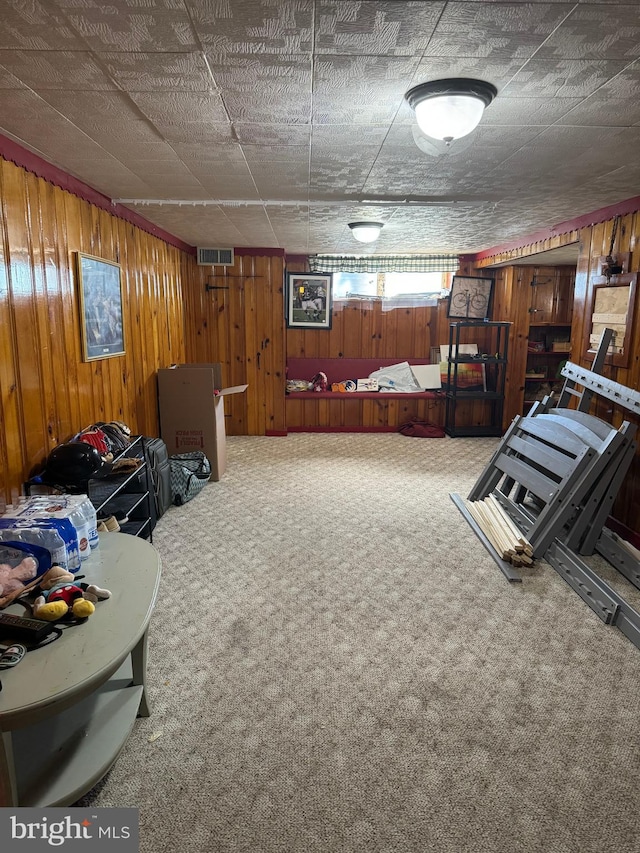 basement featuring carpet floors and wood walls