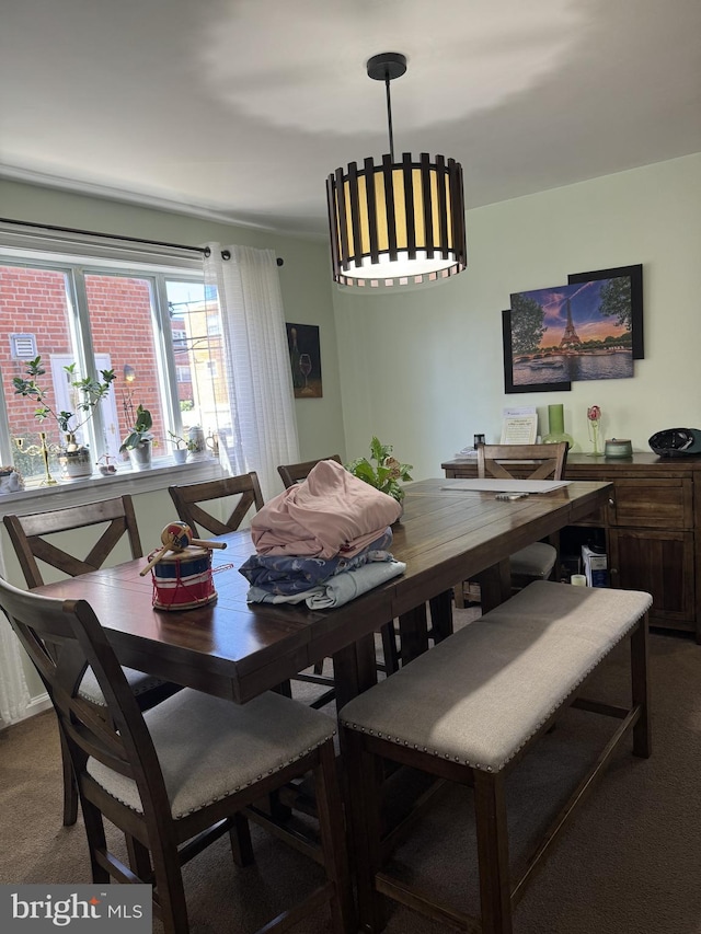 dining room featuring a notable chandelier and carpet flooring