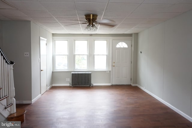 foyer entrance featuring a paneled ceiling, radiator heating unit, dark hardwood / wood-style floors, and ceiling fan