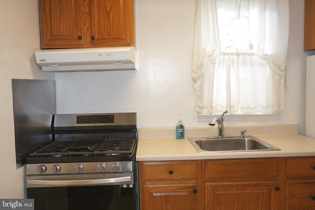 kitchen with stainless steel range with gas stovetop, sink, and exhaust hood