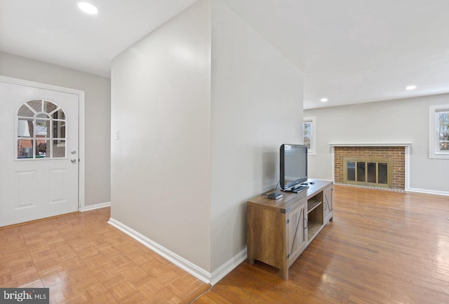 entrance foyer with a fireplace and light wood-type flooring