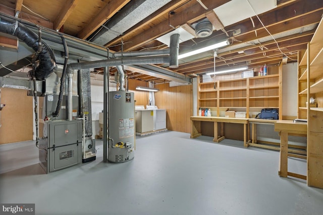 basement with water heater, heating unit, and independent washer and dryer