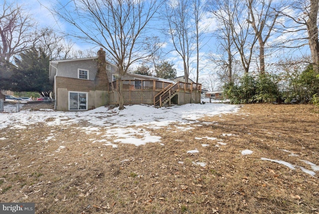 snow covered house with a wooden deck