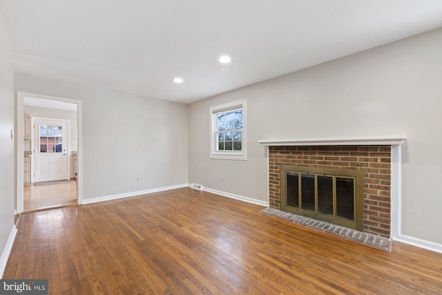 unfurnished living room with hardwood / wood-style flooring and a fireplace