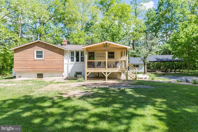 back of property with a chimney, a yard, and stairs