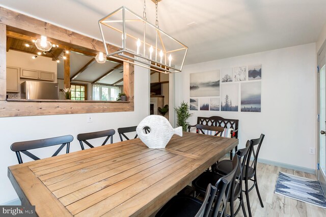 dining area featuring a chandelier, baseboards, and light wood-style floors