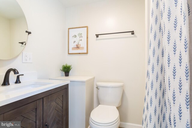 bathroom featuring baseboards, toilet, a shower with curtain, and vanity