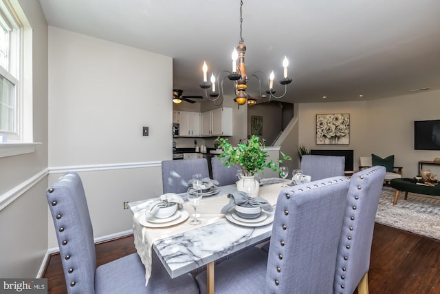 dining area featuring dark hardwood / wood-style floors and ceiling fan with notable chandelier