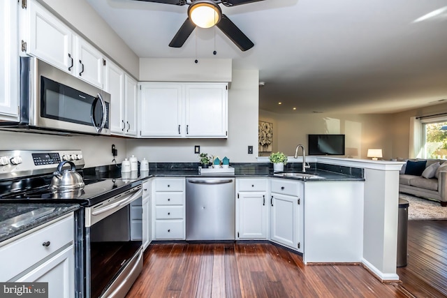 kitchen with sink, appliances with stainless steel finishes, white cabinets, and dark hardwood / wood-style flooring