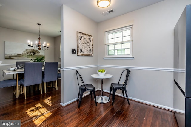 dining room featuring dark wood-type flooring and a chandelier