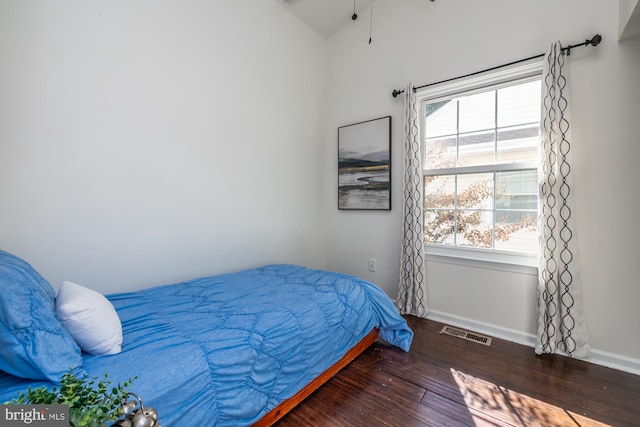 bedroom with vaulted ceiling and dark hardwood / wood-style floors