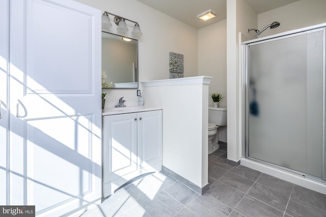 bathroom with vanity, tile patterned floors, toilet, and walk in shower