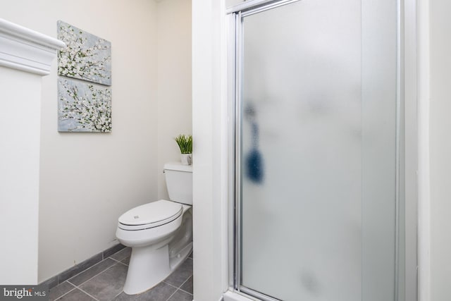 bathroom with a shower with shower door, toilet, and tile patterned flooring