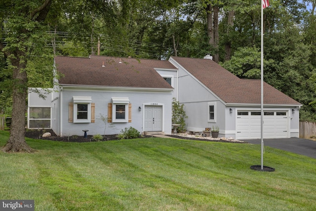 view of front of home with a garage and a front lawn