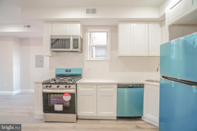 kitchen with white cabinetry, stainless steel appliances, and light wood-type flooring