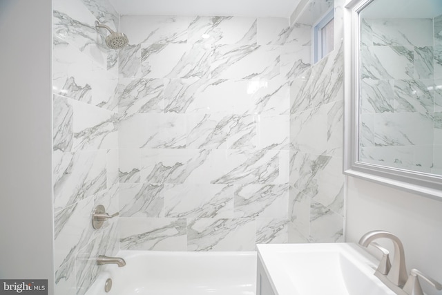 bathroom featuring vanity and tiled shower / bath