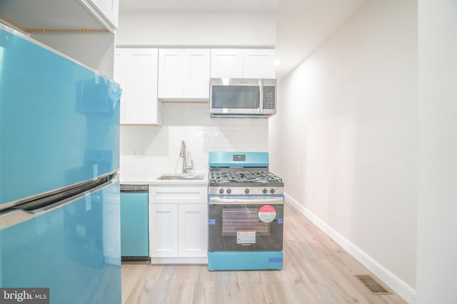 kitchen featuring light hardwood / wood-style flooring, white cabinets, stainless steel appliances, and sink