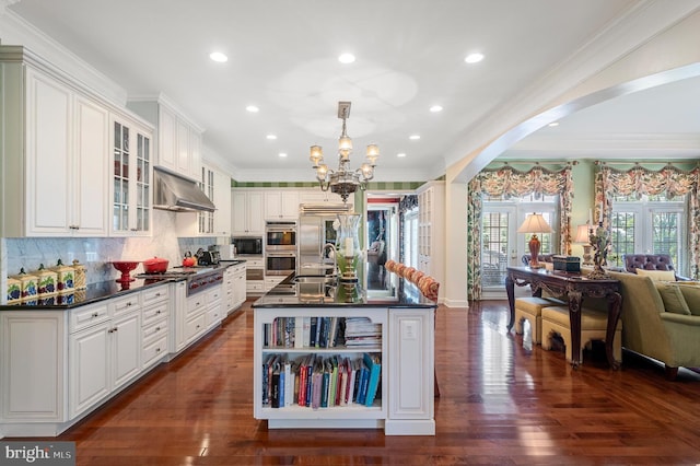 kitchen with pendant lighting, white cabinetry, an island with sink, sink, and stainless steel appliances