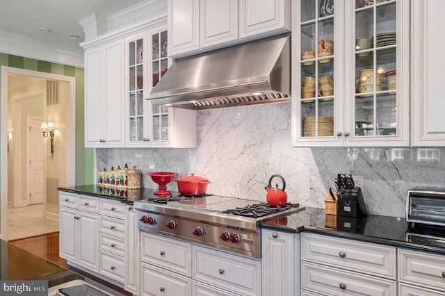 kitchen featuring ventilation hood, tasteful backsplash, white cabinets, stainless steel gas cooktop, and crown molding