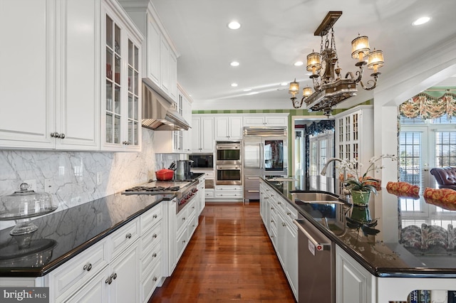 kitchen featuring white cabinets, stainless steel appliances, a sink, recessed lighting, and decorative backsplash