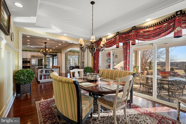 dining area featuring crown molding, an inviting chandelier, a raised ceiling, dark wood-style floors, and recessed lighting